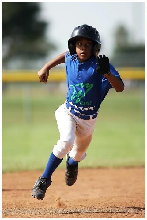 A child sprints energetically across the baseball