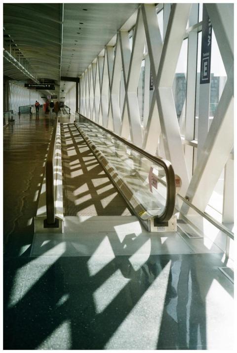 Bright airport corridor featuring a moving walkway