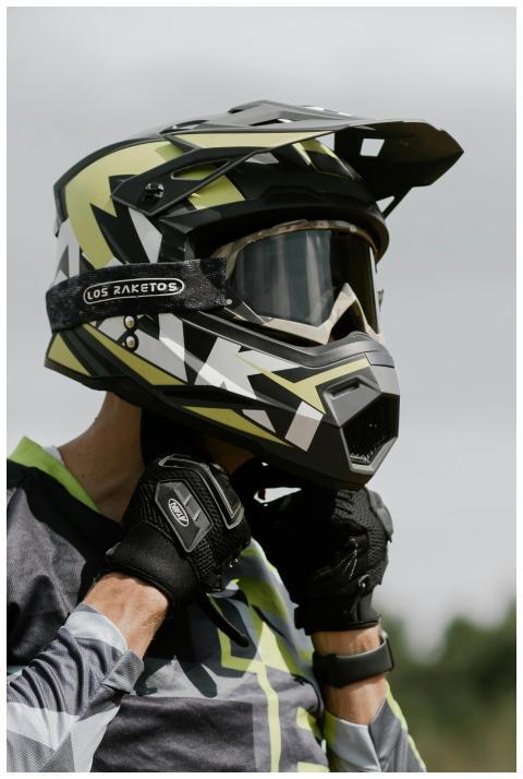 A motorcycle rider adjusts their helmet in outdoor