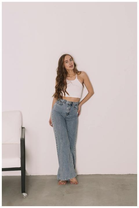 Woman with long wavy hair posing indoors in a casu