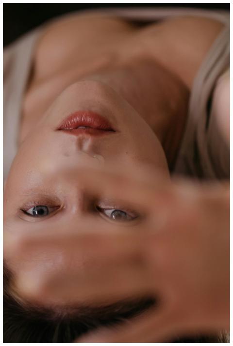 Close-up portrait of a woman, hand partially cover