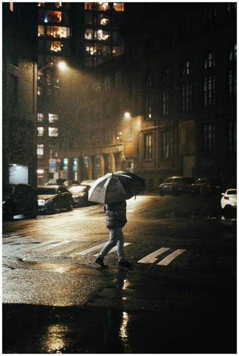 A lone figure walks through a rainy Seattle street