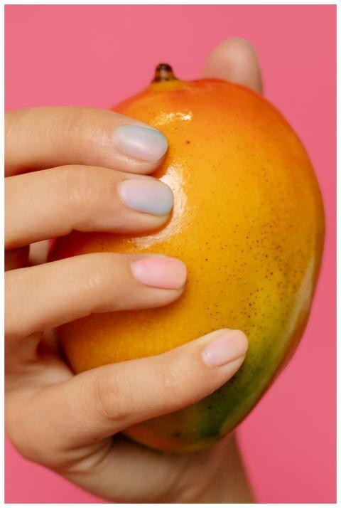 A close-up shot of a hand with painted nails holdi