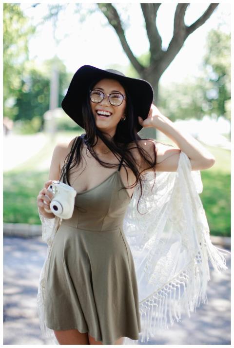 Cheerful woman in a boho dress with a camera enjoy
