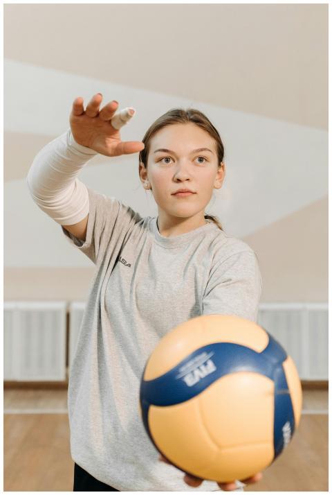 Young female volleyball player in motion, serving