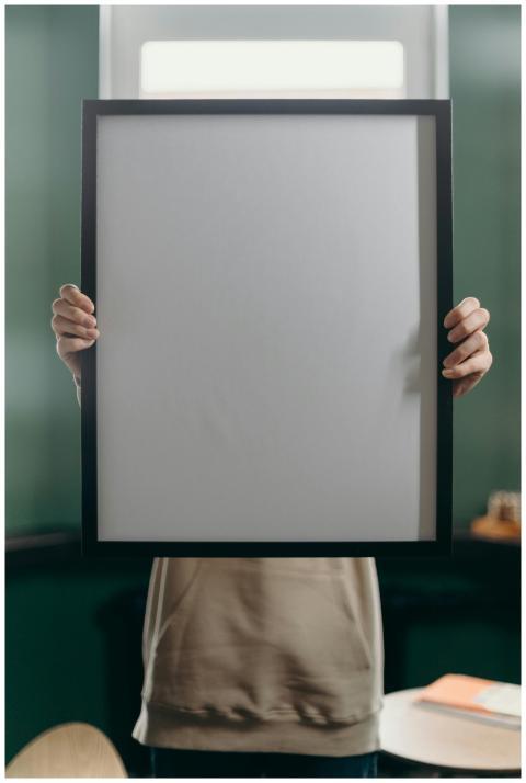 An anonymous individual holding a blank black fram