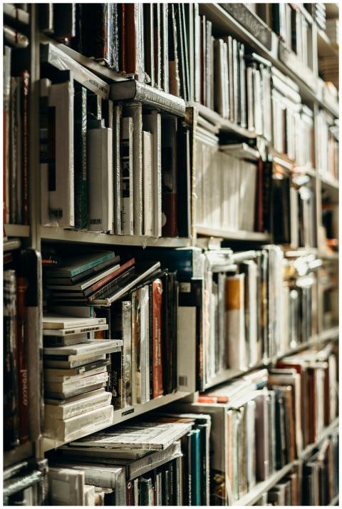 A close-up view of a stacked bookshelf in a warmly
