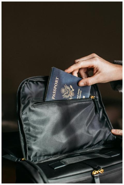 Close-up of a person placing a passport into a lea