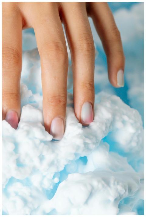 A close-up shot of manicured hand gently touching