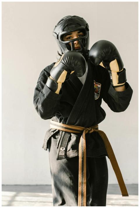 A martial artist wearing black gear and a brown be