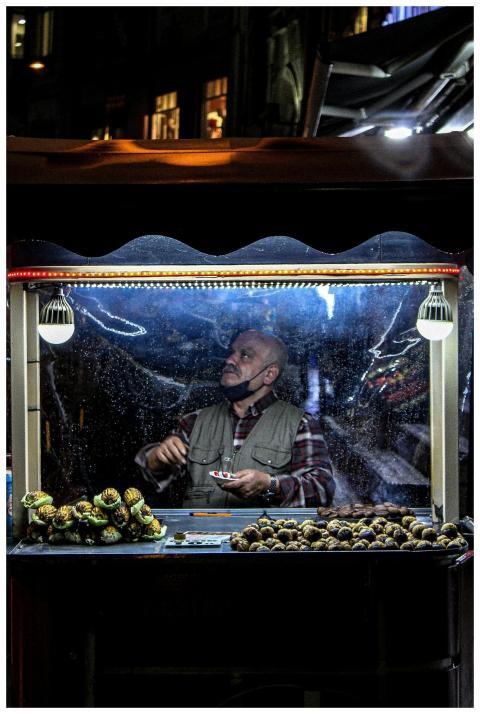 Street vendor serves food at night under illuminat