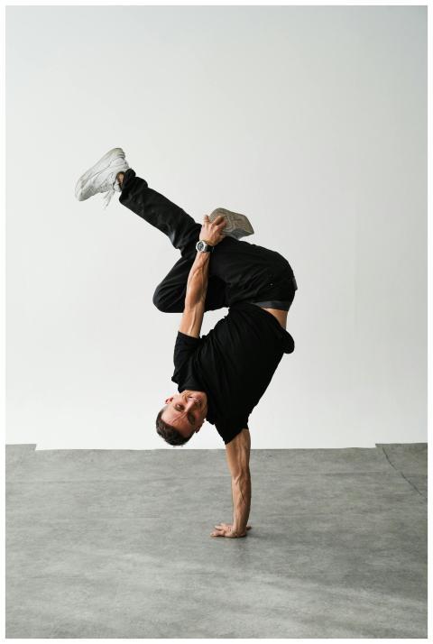 A dynamic breakdancer executing a handstand in a m