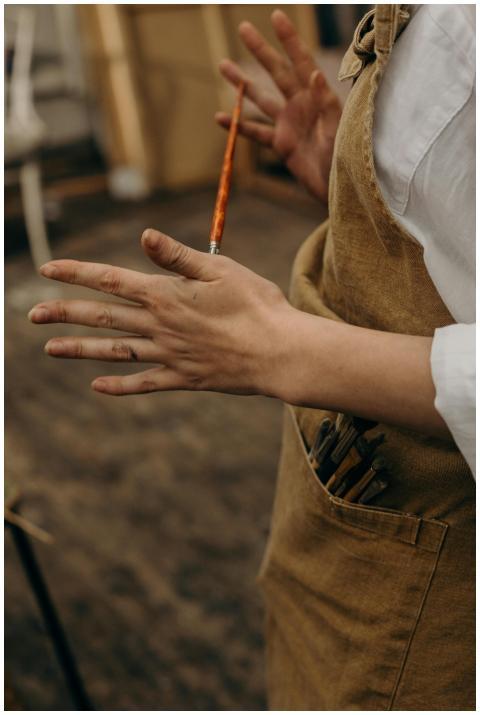 Close-up of artist's hands with paintbrush in a st