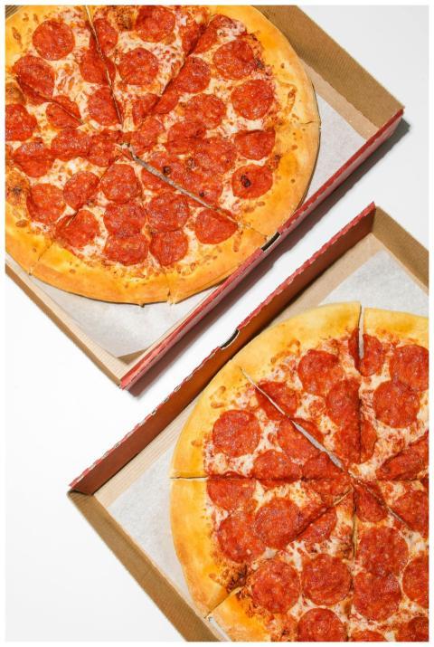 Two freshly baked pepperoni pizzas in open cardboa