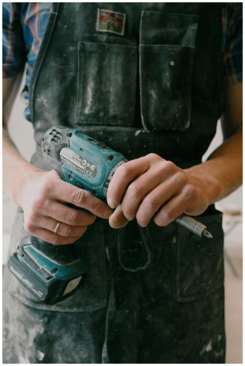 Crop anonymous mechanic in uniform with wireless d