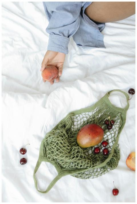 Close-up of hand holding fruit with cherries and m