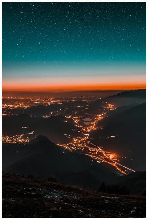 A breathtaking view of a city lit up beneath a sta