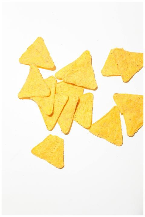 A group of crunchy yellow tortilla chips on a whit