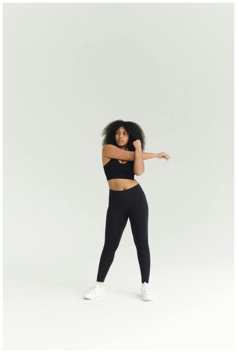 African American woman in activewear stretching du
