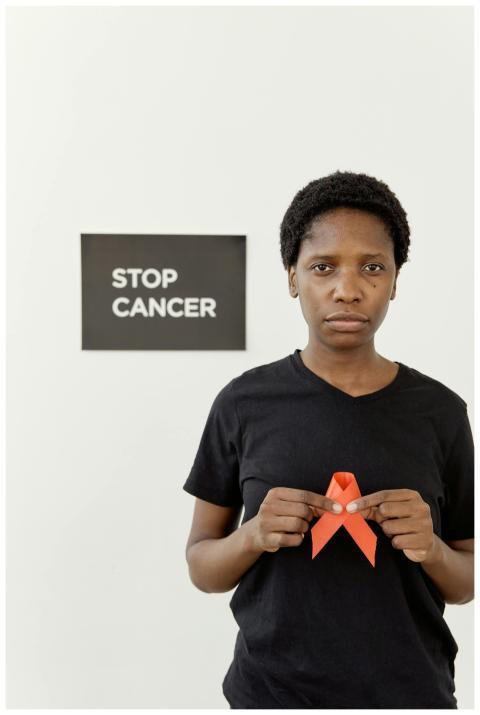 Black woman holding red awareness ribbon next to '
