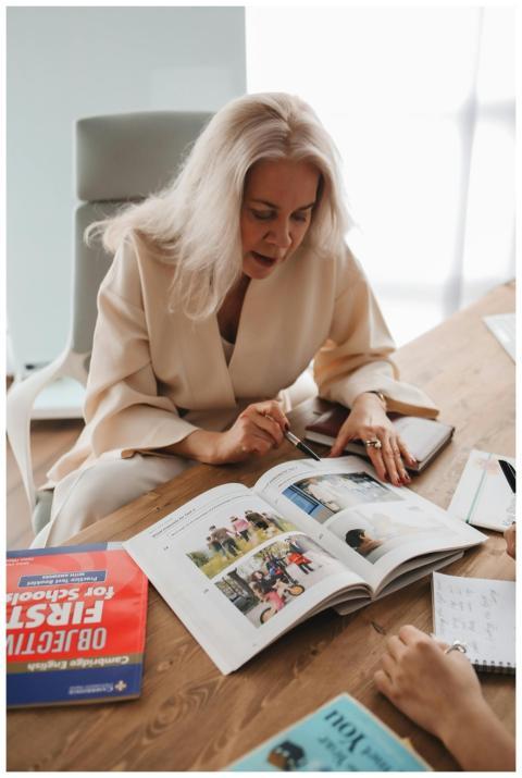 An experienced teacher guides students with textbo