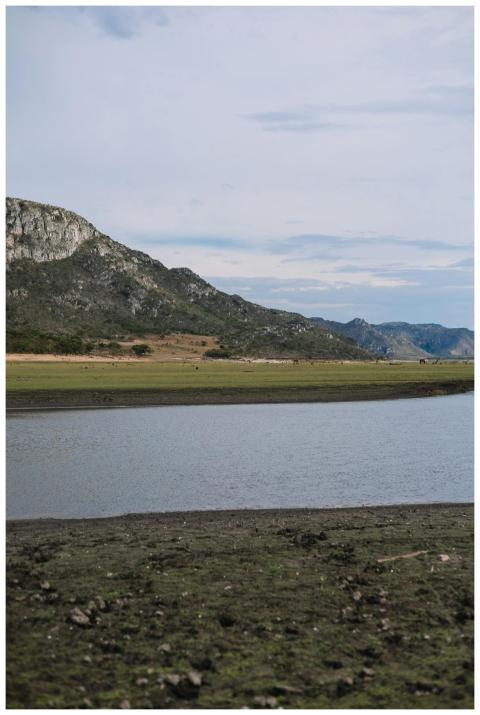 A tranquil mountain lake scene with rugged cliffs