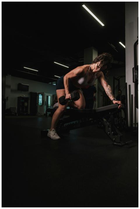 Woman working out in a gym, emphasizing strength a