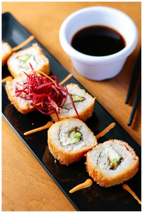Crispy sushi rolls served with soy sauce, captured