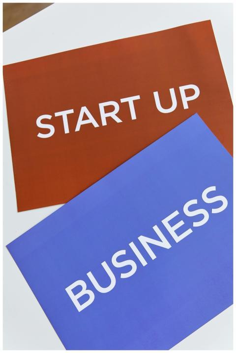 Two colorful placards with 'START UP' and 'BUSINES