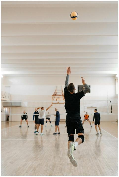 Men engaging in a dynamic volleyball match indoors