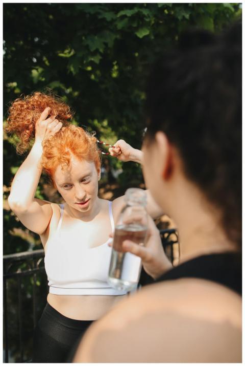Two women staying hydrated while engaging in outdo
