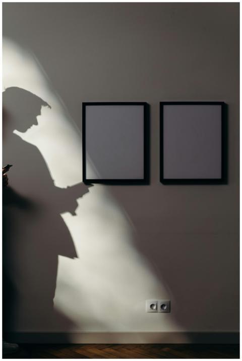 A man with a smartphone is casting a shadow on a m