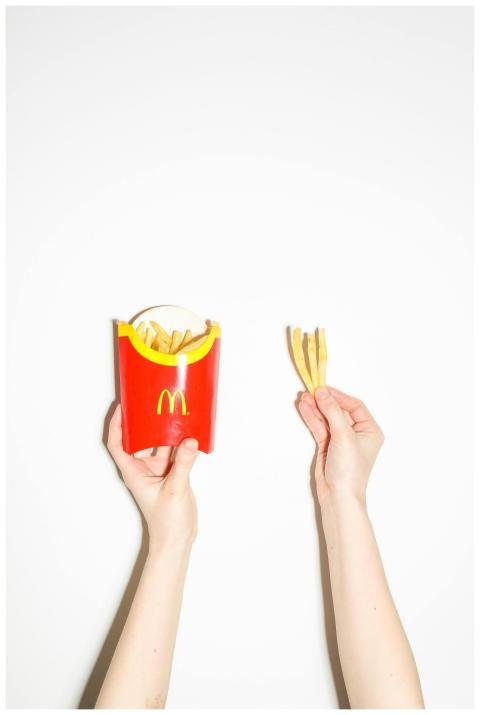 Close-up of hands holding McDonald's fries and box
