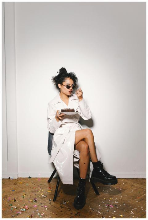 Stylish woman with sunglasses sitting indoors, enj