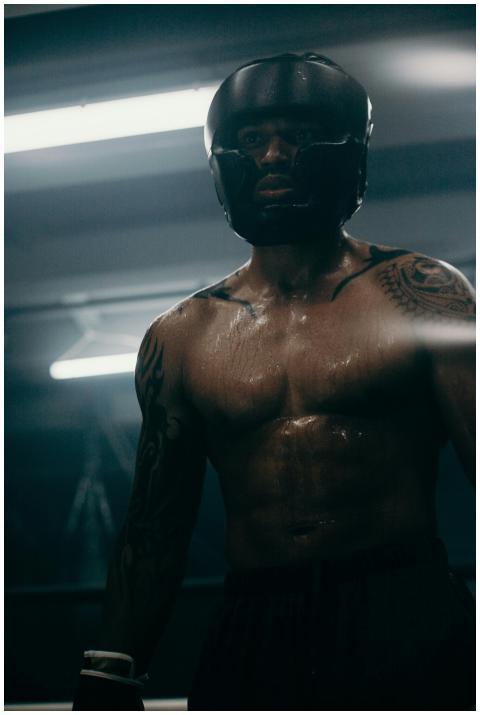 Focused boxer in a gym environment, showcasing str