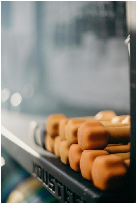 Stacked orange dumbbells on a gym rack, perfect fo