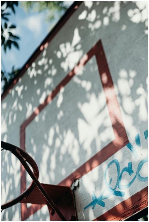 Close-up of a rustic basketball hoop and graffiti,