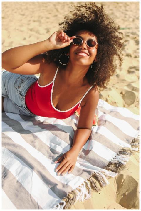 Smiling woman enjoying sunny day on the beach with