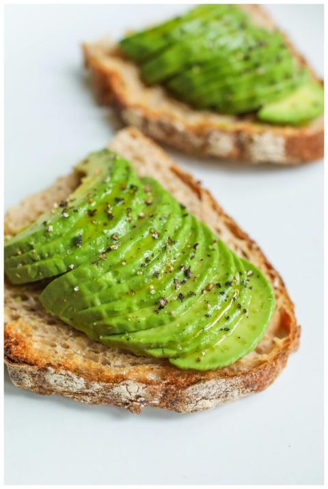Sliced avocado atop sourdough bread, seasoned with