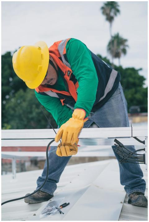 A construction worker wearing PPE installs electri