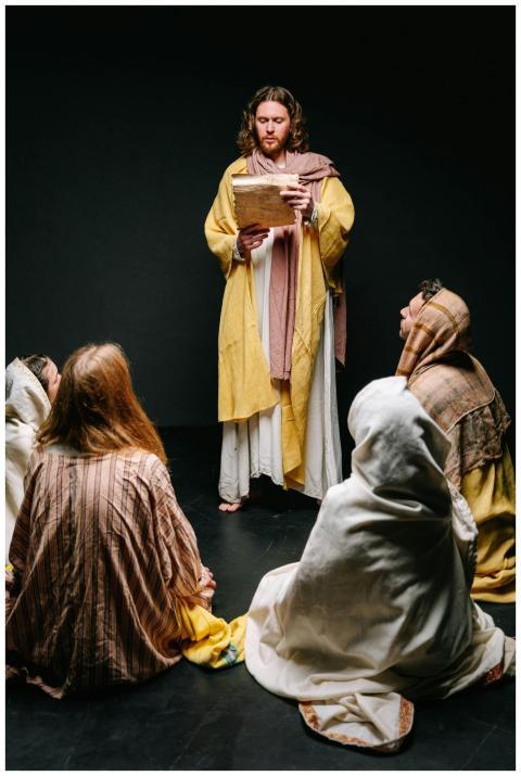 Jesus reading to a group of apostles in traditiona