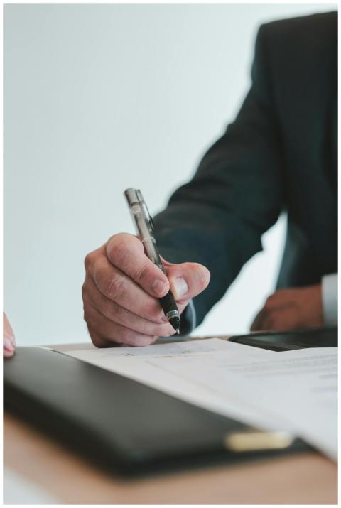A businessman in a suit signing a contract in an o