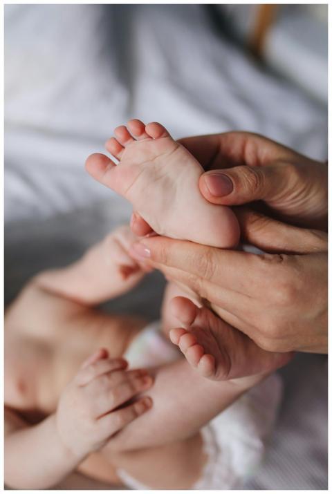 A close-up of a parent's hands gently massaging a