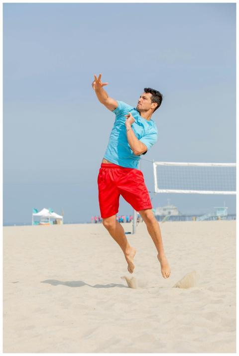 An athletic man in midair during a thrilling beach