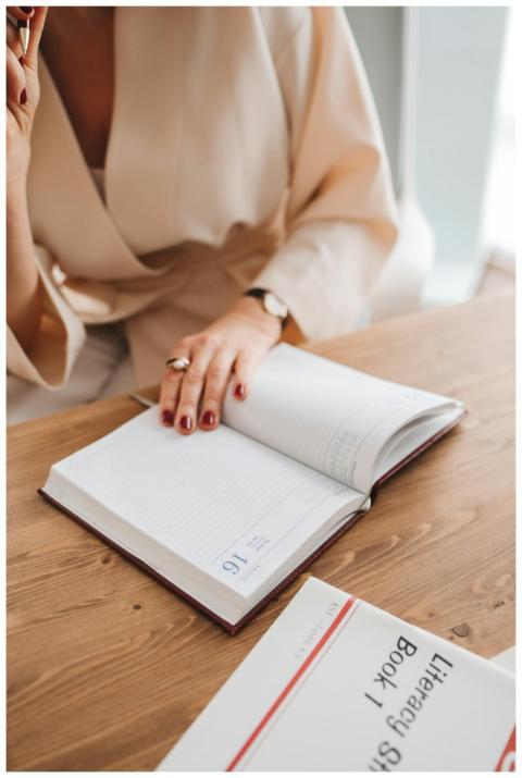 Adult woman writing in an open notebook at a woode