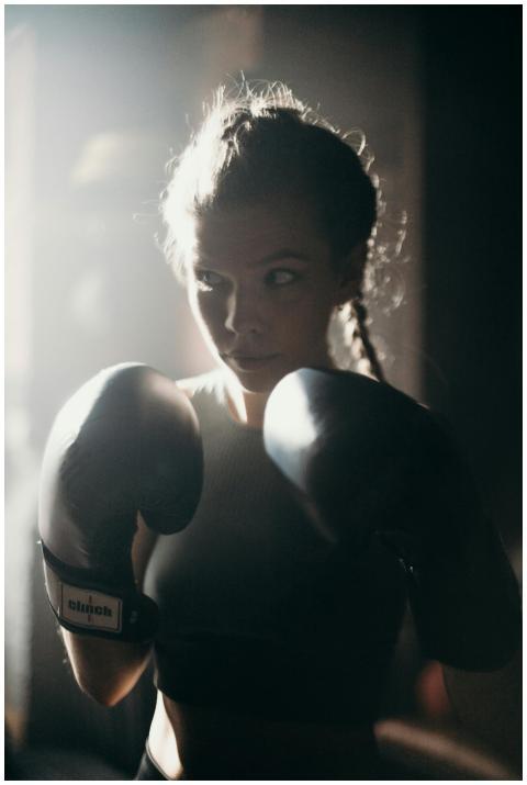 Determined female boxer in training, wearing glove