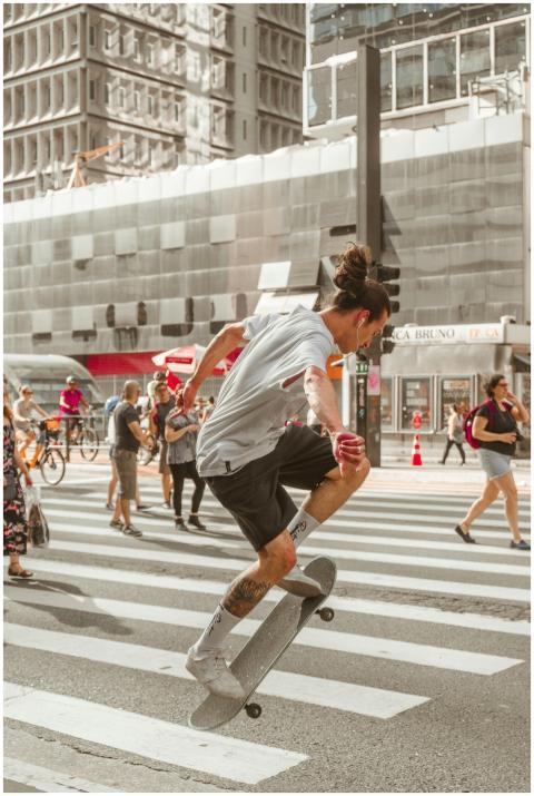 Skateboarder performing a trick on a busy city ped