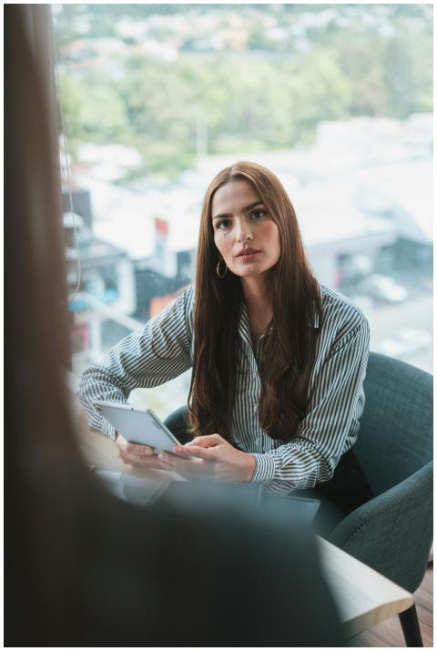 Businesswoman sitting in a modern office, using a