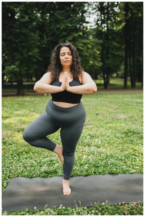 Confident plus size woman practicing yoga outdoors