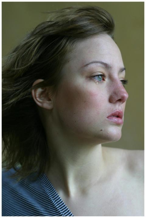 A young woman looks thoughtfully into the distance